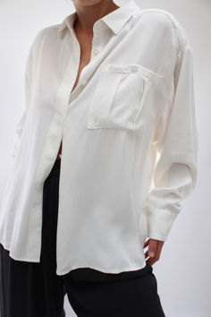 The Nora Relaxed Button Up is a thoughtfully constructed blouse with a focus on tailored details and a functional fit. A refreshing tailored button-up, essential year round, the Nora features a front hidden placket, pleated chest pocket, relaxed sleeves, and generous cuffs. Timeless Relaxed Fit Shirt For Work, Timeless Relaxed Fit Workwear Shirt, Classic Formal Tops With Pockets, Timeless Relaxed Fit Tops For Work, Timeless Relaxed Fit Workwear Tops, Formal Tops With Welt Pockets And Relaxed Fit, Timeless Blouse For Work With Concealed Placket, Formal Shirt With Pockets And Relaxed Fit, Timeless Button-up Top With Hidden Buttons