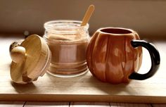 there are two mugs with spoons next to each other on a wooden tray