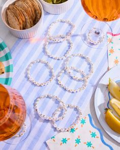 a table topped with plates and bowls filled with food next to glasses full of wine