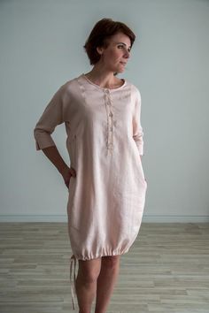 Loose fit linen button up tunic. Soft linen dress with three quarter sleeve and intricate details. FEATURES:Boat necklineButton up frontTie up bottomThree quarters dolman sleeveRuffle sidesPocketsModel is 174 cm/5'7" tall, size S-M. SIZE:S-M | EU 36-38 | US 6-10-Chest 110 cm / 43.3"-Back Center Length 93 cm / 36.6"-Hips 118 cm | 46.4"M-L | EU 38-42 | US 10-12L-XL | EU 42-46 | US 12-16COMPOSITION:100% - local medium weight linenOeko-Tex certified 100 % linen fabric* IMPORTANT: We can make clothes Casual Linen Dress With Button Cuffs For Spring, Summer Linen Dress With Button Cuffs For Daywear, Fitted Linen Tunic For Summer, Spring Button-up Tunic With Buttons, Elegant Linen Dress With 3/4 Sleeves, Spring Linen Tunic With Buttons, Spring Daywear Linen Dress With Button Closure, Summer Tunic With Buttons And Relaxed Fit, Long Sleeve Linen Dress With Buttons