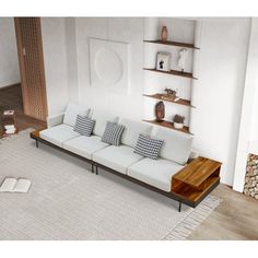 a white couch sitting on top of a living room floor next to a book shelf