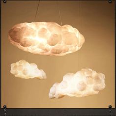 two clouds are suspended from the ceiling in front of a light fixture that is lit up