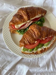 a croissant sandwich with meat and vegetables on it