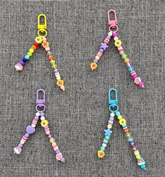 three pairs of colorful beaded dog leashes on a gray background, one has a clip and the other has two clips attached to it