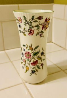 a white vase sitting on top of a tiled counter