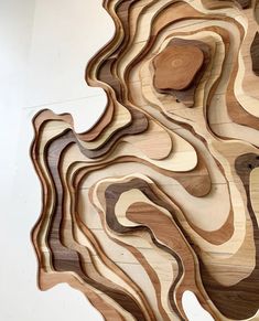 a wooden sculpture with wavy shapes on the wall