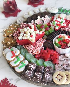 a platter filled with lots of different types of cookies and candies on top of a table