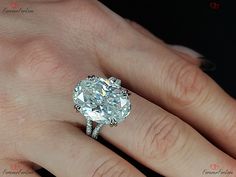 a woman's hand with a diamond ring on top of her finger and an engagement band