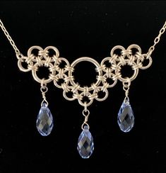 "This elegant chainmaille necklace is an interpretation off of the Stepping Stones weave created by Corvus Chainmaille.   The pendant is made from sterling silver filled jump rings and genuine Swarovski crystal briolettes, and is a beautiful, feminine interpretation on chainmaille. This unique pendant is sure to be a conversation starter!  The pendant measures 2\" across and is 1.5\" long at the center point. The Swarovski crystals come in 17 different colors* so you can completely personalize t Jump Rings Tutorial, Jump Ring Necklace, Chainmaille Jewelry Patterns, Chain Maille Necklace, Chainmaille Necklace, Jump Ring Jewelry, Chainmaille Jewelry, Wire Wrap Jewelry Designs, Chainmail Jewelry