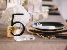 the table is set with black and gold place settings