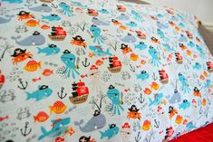 a bed topped with blue and red bedspread covered in cartoon animals on it