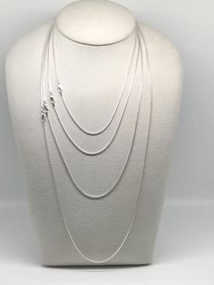 Featuring a smooth, fluid look and bright finish, this round sterling silver seamed snake chain necklace is a great option for pendants that benefit from a strong, slender chain. Seamed snake chain is created with soldered, machine-made curb-style chain that is compressed twice, producing the snake-like appearance and leaving behind a telltale seam visible along its length. This chain is plated with fine silver to ensure a bright white color and to help protect against tarnish. A lovely chain to Silver Snake Chain Jewelry, Minimalist Snake Chain Necklace With Sterling Silver Clasp, White Gold Sterling Silver Snake Chain Necklace, Sterling Silver Snake Chain Jewelry, Silver Snake Chain Necklace With Adjustable Chain, Sterling Silver Snake Chain Necklace, Silver Snake Chain Jewelry With Delicate Chain, Elegant Sterling Silver Snake Chain Necklace With Adjustable Chain, Sterling Silver Delicate Snake Chain Necklace Gift