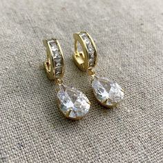 "These Heatherly Designs earrings are a modern take on bridal or if you like your bling, perfect for everyday. They feature huggie hoops paved with square princess cut CZ, which CZ pears are set in simple prong settings and dangle beneath. These earrings are solid jewelers brass plated in 14k. ●Nickel free ●Size: 1 1/2\" x 3/8\" or 3.81 x 1cm ●Hoop Width: 1/8\" or .32cm ●Arrives in our signature Heatherly gift box. Handmade with ❤ by Heather ● ● ● ● ● ● ● ● ● ● ● ● ● ● ● ● ● ● ● ● ● ● ● ● ● ● ● Modern Bridal Earrings, Pear Earrings, Box Handmade, Modern Bridal, Cubic Zirconia Earrings, Leverback Earrings, Zirconia Earrings, Delicate Earrings, Pink Earrings