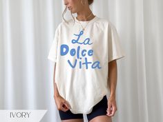 La Dolce Vita, retro Italian travel poster style graphic tshirt for women. Great for a girl's trip or souvenir shirt.   Available in the colors Ivory, White, Banana, Pepper & Orchid. Relaxed unisex fit. True to size. Size up for an oversize look.  ~made with 100% ethically grown, ring-spun US cotton for long-lasting comfort. ~relaxed fit  ~pre-shrunk fabric ensures a consistently great fit All t-shirts are made to order and can only be refunded if damaged or incorrect. Please message me before p Italy Girls Trip, Italy Girl, Retro Italian, Italian Travel, Travel Tshirt, Aesthetic Retro, Vintage Travel Poster, Pinterest Aesthetic, Fashion Poster