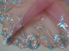 a pink and blue lace with flowers on it