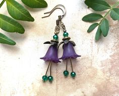 These are gorgeous flower earrings with antiqued floral caps, purple flowers and teal glass dangle drops. Beautiful for a bohemian nature inspired wedding or as a gift for her. Very pretty earrings. The gentle breeze gives these light airy earrings a fluid movement that creates a true sense of freedom as they dangle and swing in the fresh air. So irresistibly feminine and lightweight you will forget you are wearing them. Handcrafted in Finland by Selma Dreams. The earrings are made of vintage style bronze. All parts are lead and nickel safe. The earrings come in a lovely Selma Dreams gift box ready for gifting. If you have any questions, please feel free to ask. All my bell flower earrings are available in more colours than shown. Do contact me if you are looking for a custom colour. Handmade Vintage Purple Flower Earrings, Purple Flower Bohemian Earrings, Bohemian Purple Flower Earrings, Vintage Purple Flower Earrings, Bunny Valentines, Fluid Movement, Teal Glass, Nature Inspired Wedding, Dream Gift