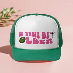 a pink and green trucker hat with the words, run by older on it