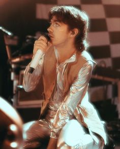 a man in shiny clothes holding a microphone