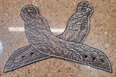 a pair of scissors sitting on top of a marble counter with holes in the middle