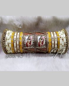 Make A Bold Statement With This Yellow & White Photo Chura Set. Beautified With High Quality Glass Stone Beaded. Photo Kada Is Prettified With Rajwadi Style Hand Painting Meenakari And High Quality Glass Kundan Fitting. Be An Angel And Create A Splendid Impact On Everyone By Wearing This Gorgeous Design. This is a set of 30 Bangles (15 For Each Hand). Note: We Can Put Your Picture Into The Frame On Center Bangle. Simply Send Us Your Picture After Ordering It. White Bridal Sets For Ceremonial Festive Occasions, Festive White Bridal Sets For Ceremonial Occasion, White Cutdana Bridal Sets For Wedding, Festive White Bridal Sets For Marriage, White Traditional Wear For Marriage And Festivals, White Bridal Sets With Stone Work For Festivals, White Kundan Jewelry For Wedding And Festivals, White Bridal Sets With Zari Work For Festive Occasions, Festive White Bridal Sets With Zari Work