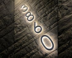 three different images of the letters and numbers on a brick wall, one is lit up at night