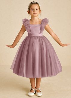 Cherub is a dreamy A-line creation in matte satin and tulle, featuring elegant crossed straps and a square neckline. Its standout cascading ruffles add a touch of whimsy, making it a perfect choice for enchanting celebrations. Dusty Rose Flower Girl, Dress Poses, Girls Formal Dress, Tea Length Flower Girl Dress, Tea Length Tulle, Military Ball Dresses, Sage Dress, Special Event Dresses, Lace Bride