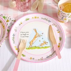 a pink and white table setting with bunny plates, utensils and teddy bears