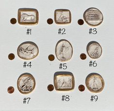 an assortment of ancient roman coins with numbers and symbols on display in a white box