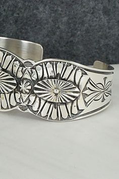 This intricate sterling silver bracelet was made by Navajo silversmith Derrick Gordon. The inside is signed Derrick and stamped sterling.Size: 5 7/8" (will fit up to a 7" wrist)Gap: 1 1/8"Length: 1"Free shipping on all orders! We ship with USPS and always include tracking. All orders ship within a day of payment.Returns are accepted up to 30 days after you receive your order. Just send us a message. Our shop offers cash back or store credit. The item must be returned in new condition. Western Sterling Silver Cuff Bracelet With Concho, Western Silver Cuff Bracelet With Concho, Western Silver Concho Cuff Bracelet, Western Sterling Silver Cuff Bracelet, Western Style Sterling Silver Cuff Bracelet, Handmade Western Silver Cuff Bracelet, Western Style Silver Cuff Bracelet Gift, Adjustable Western Sterling Silver Bracelet, Western Style Silver Cuff Bracelet As A Gift