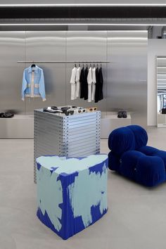 two blue chairs sitting next to each other in front of a clothing store display case