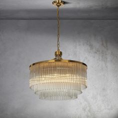 a chandelier hanging from the ceiling in a room with concrete walls and flooring