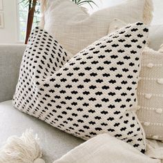 pillows on a couch with tassels and pom - poms