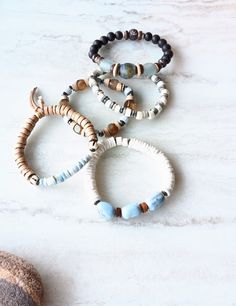 Beautiful mix of of light and dark and of neutrals plus a few pops of beachy color. White, beige, silver blue, gray-green, gray-blue, brown, dark browns, and touches of mustards. Bone beads, fused glass disks, recycled glass beads, Ebonywood, colorful glass Chevron beads, coconut disks, Agate, and several Jasper gemstones. Blended in with natural shell, mixed metal accents, and various spacer beads. The item/s pictured is the item you will receive. Bracelets are 7.0" to 7.5" in length.  HavSolSt Bohemian Adjustable Bracelets With Recycled Glass, Earthy Natural Stone Beaded Bracelets For Beach, Adjustable Blue Beaded Earthy Bracelet, Adjustable Earthy Blue Beaded Bracelets, Adjustable Bohemian Bracelets With Recycled Glass, Adjustable Bohemian Bracelet With Recycled Glass, Adjustable Bohemian Bracelets Made Of Recycled Glass, Earthy Hand-wrapped Bracelets For The Beach, Earthy Hand Wrapped Bracelets For Beach