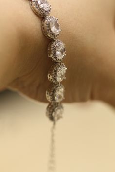 Elegant bridal bracelet made with Cubic Zirconia set in rhodium silver plated settings .6 inches long with a 2 inch extension chain and lobster clasp. Matching bracelet available at this link: https://www.etsy.com/listing/177345488/bridal-earrings-cubic-zirconia-earrings?ref=shop_home_active_1 Please contact me if you like more then one. Thank you for visiting SimplyChic93 Glamorous Wedding Bracelets In Cubic Zirconia, Classic Cubic Zirconia Crystal Bracelet For Wedding, Glamorous Cubic Zirconia Wedding Bracelets, Elegant Jewelry With Handset Cubic Zirconia Stones, Elegant Cubic Zirconia Jewelry With Handset Stones, Elegant Silver Crystal Bracelet With Bling, Formal Sparkling Cubic Zirconia Bracelets, Elegant Silver Crystal Bracelets, Cubic Zirconia Jewelry With Handset Stones As Gift