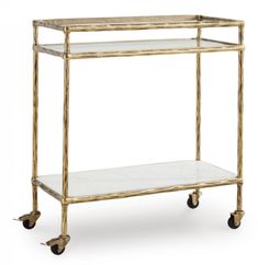 a gold metal and glass shelf with wheels