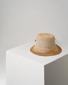 This stylish CROCHET KHOYA unisex bucket hat is crafted with natural raffia, featuring a subtle orange logo and decorated with gold-plated metal accessories and hand-assembled pearl accents in brown and yellow. Each hat is made with precision in Florence and completed with artistry in Stockholm. Raffia Crochet, Orange Logo, Pearl Accessories, Stylish Crochet, Metal Accessories, Hat Sizes, Stockholm, Florence, Bucket Hat