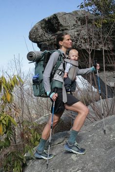 a woman with a baby on her back hiking