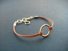 "dainty bracelet made with matte 16K gold plated over brass little hoop and Marigold leather cord bracelet measures total 7.5\" with 1\" extension chain and closed with gold plated lobster clasp hoop measures 15mm diameter bracelet can be made to any length plus 1\" extension chain so you can adjust length, simply leave a note to seller while check out otherwise you'll get 6.5\" plus 1\" extension chain. matching necklace; https://www.etsy.com/listing/62658576/matte-yellow-gold-hoop-pendant-neck Adjustable Matte Gold Minimalist Bracelet, Adjustable Circular Everyday Jewelry, Gold Bracelets With Adjustable Waxed Cord, Adjustable Everyday Jewelry With Gold Clasp, Adjustable Brown Hoop Jewelry, Gold Bracelet With Adjustable Waxed Cord, Gold Bracelets With Adjustable Cord For Everyday, Adjustable Gold Open Circle Jewelry, Everyday Nickel-free Jewelry With Waxed Cord