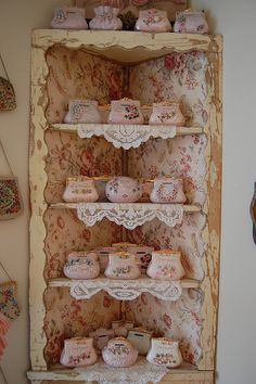 an old china cabinet with lace doily on the top and cup holders below it