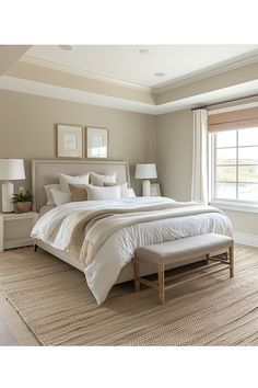 a large bed sitting in a bedroom next to two lamps on either side of a window