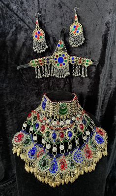 Exquisite Afghan Jewelry Set - Perfect for Special Occasions🇦🇫 Add a touch of exotic elegance to your look with our stunning Afghan jewelry set. Handcrafted by skilled artisans, each piece is a unique work of art that captures the rich cultural heritage of Afghanistan. This set includes a dazzling necklace, matching earrings, and a Tikka headpiece, all intricately designed with traditional Afghan motifs and embellished with vibrant Multicoloured gemstones. Handmade Multicolor Jewelry For Traditional Ceremonies, Adjustable Multicolor Ceremonial Jewelry, Adjustable Multicolor Jewelry For Ceremonial Occasion, Multicolor Necklace For Traditional Festivals, Multicolor Necklaces For Traditional Ceremonies And Festivals, Ceremonial Multicolor Beaded Jewelry, Bohemian Silver Jewelry Sets With Stone Work, Multicolor Necklaces For Festivals And Traditional Ceremonies, Heavy Multicolor Jewelry For Ceremonial Occasions