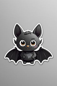 a black bat sticker sitting on top of a gray surface with an orange eyes