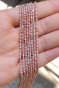 a hand is holding three strands of pearls