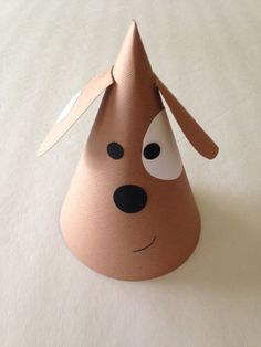 a paper cone with a dog's head sticking out of it, on a white surface