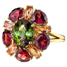 This happy ring designed with a kaleidoscope of gems is sure to make you smile! A vivid green tourmaline oval is encircled by rounded pear-shaped garnets and marquise shaped precious topazes in a unique combination of gemstone colors and shapes that will be your "go to" ring for fall, or anytime you want to lift your spirits! Handmade in 18k yellow gold by our jewelers in Los Angeles. Green tourmaline, 10.05 x 8.11mm, 2.92 carats Rounded pear shaped garnets, 6.00 x 6.00mm, 4.29 carat total Marquise shaped precious topazes, 6.00 x 3.00mm, 1.56 carat total Ring size 7 Complimentary sizing as needed Multicolor Multi-stone Emerald Oval Ring, Elegant Multicolor Oval Topaz Ring, Multicolor Oval Tourmaline Rings, Oval Multicolor Tourmaline Rings, Yellow Gold Cocktail Ring, Topaz Yellow, Gold Jewelry Outfits, Vintage Cocktail Ring, Tourmaline Jewelry