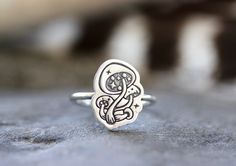 This listing is for one adorable and gorgeously detailed sterling silver magic mushroom ring. The mushroom focal piece is hand stamped onto 18 gauge sterling silver sheet and fired onto sturdy 14 gauge sterling silver wire. Wear this ring solo for simple elegance of wear it stacked with several hammered bands for an edgier, bohemian style! Perfect gift for any nature or woodland lover! It's such a magical ring! - Choose your ring size and stacking options at checkout! - Mushroom focal measures a