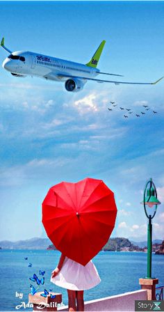 a woman is holding an umbrella and looking at the airplane flying over her head in the sky