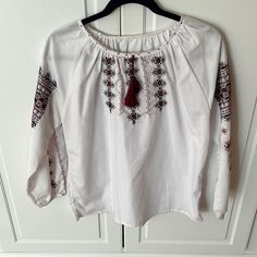 Handmade In Ukraine Where I Am From Excellent Condition Embroidered Detailing All Proceeds For Ukraine Underarm To Underarm 21 Inches Sleeve Length 15 Inches White Folk Peasant Top For Festival, White Peasant Top For Festival, White Folk Tops With Embroidered Sleeves, White Folk Top With Embroidered Sleeves, Bohemian White Peasant Top With Embroidered Sleeves, White Bohemian Peasant Top With Embroidered Sleeves, White Folk Style Embroidered Top, White Folk Embroidered Top With Embroidered Hem, Folk Style White Embroidered Festival Top