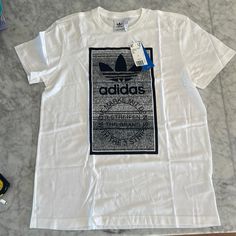 White Never Worn Adidas Logo Tee. “Traction Tongue” Size Large. Crisp! Adidas Cotton T-shirt For Streetwear, White Cotton Shirt With Logo Print, Adidas Cotton Tops For Streetwear, Urban White Tops With Logo Print, Adidas Graphic Tee Cotton T-shirt, White Adidas Shirt With Letter Print, Adidas Urban T-shirt With Graphic Print, Adidas Urban T-shirt For Streetwear, White Print Logo Graphic Tee Shirt