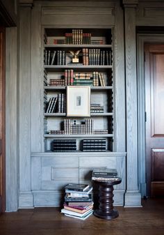 a bookshelf filled with lots of books in a room